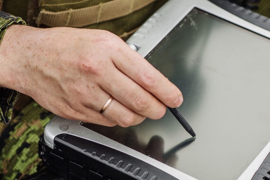 Military person writing on a ipad